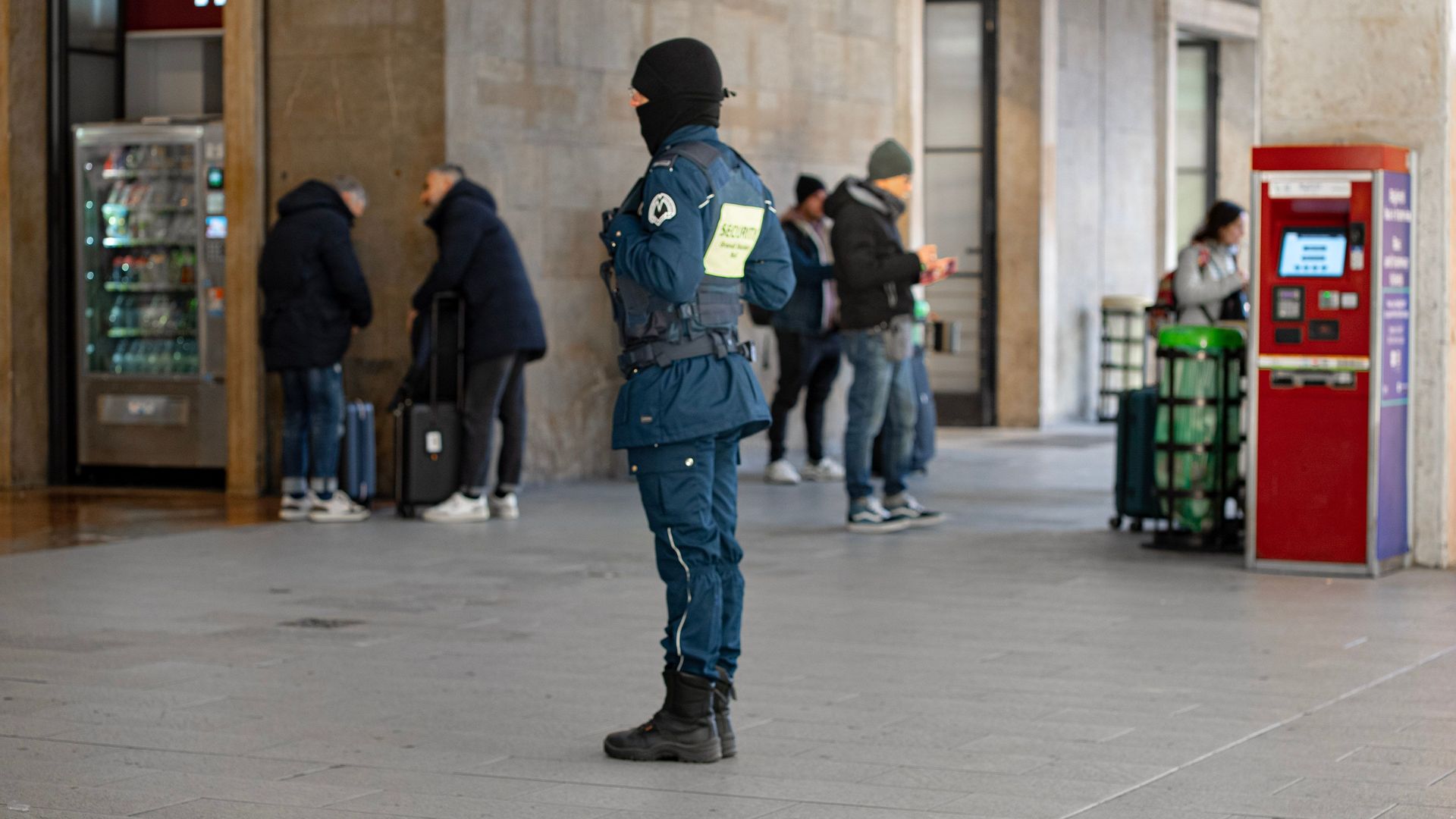 Security personnel on duty at a busy train station in Florence, Italy.