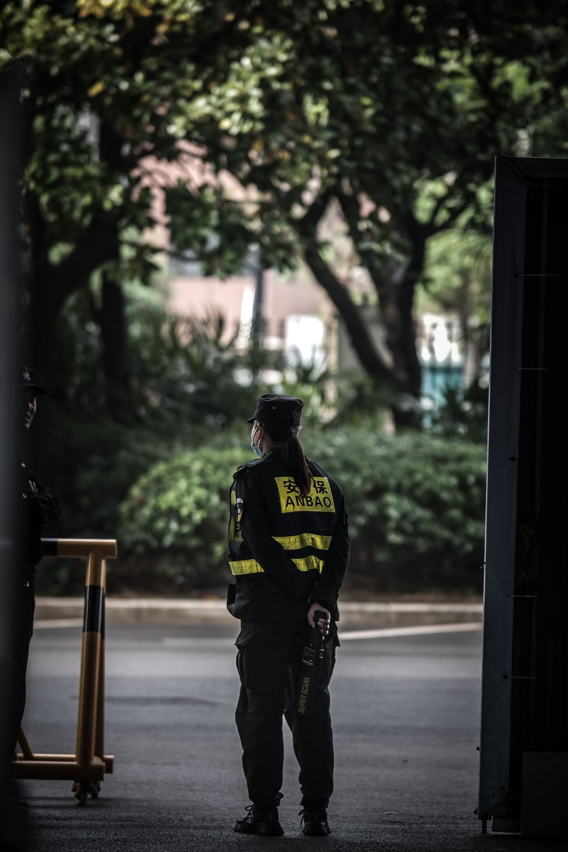 Security guard in uniform stands vigilantly outdoors in Shanghai, China.