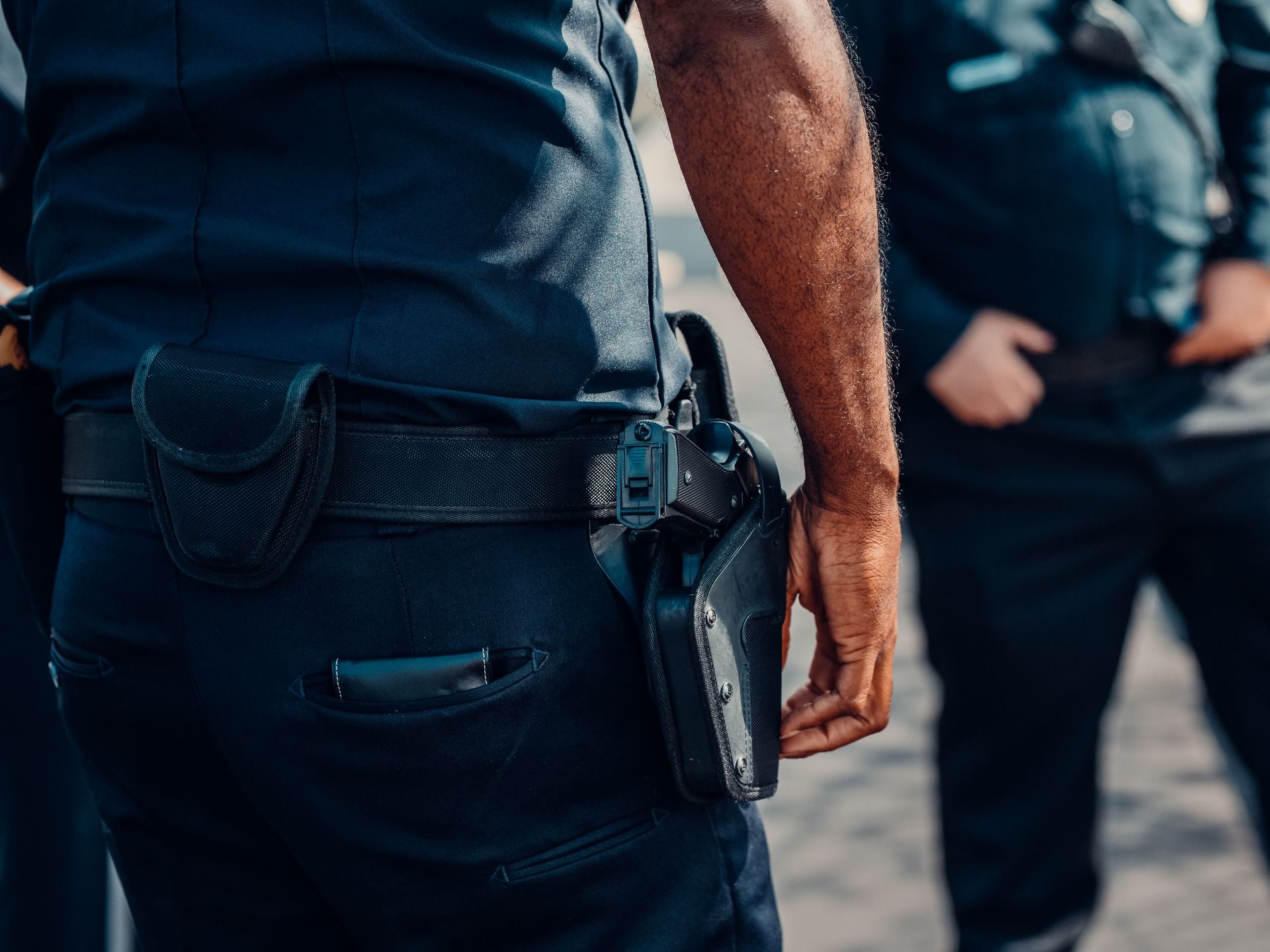 Close-up of a police officer's firearm securely holstered at the waist, conveying professionalism and readiness.